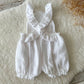 Back view of sitter photo romper made of white muslin fabric with criss crossed straps

