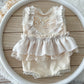 Detailed view of lace shoulder ruffles and V-back with pearl button