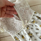Open-back detail of newborn romper with scalloped lace trim – functional view