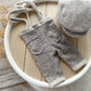 Gray baby pants and hat set on a wooden surface