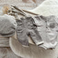 Gray newborn boy photo outfit with romper, suspenders, and flat cap for photo shoots