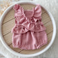 The back of the romper with elasticated ruffles on the back and bow decorations.