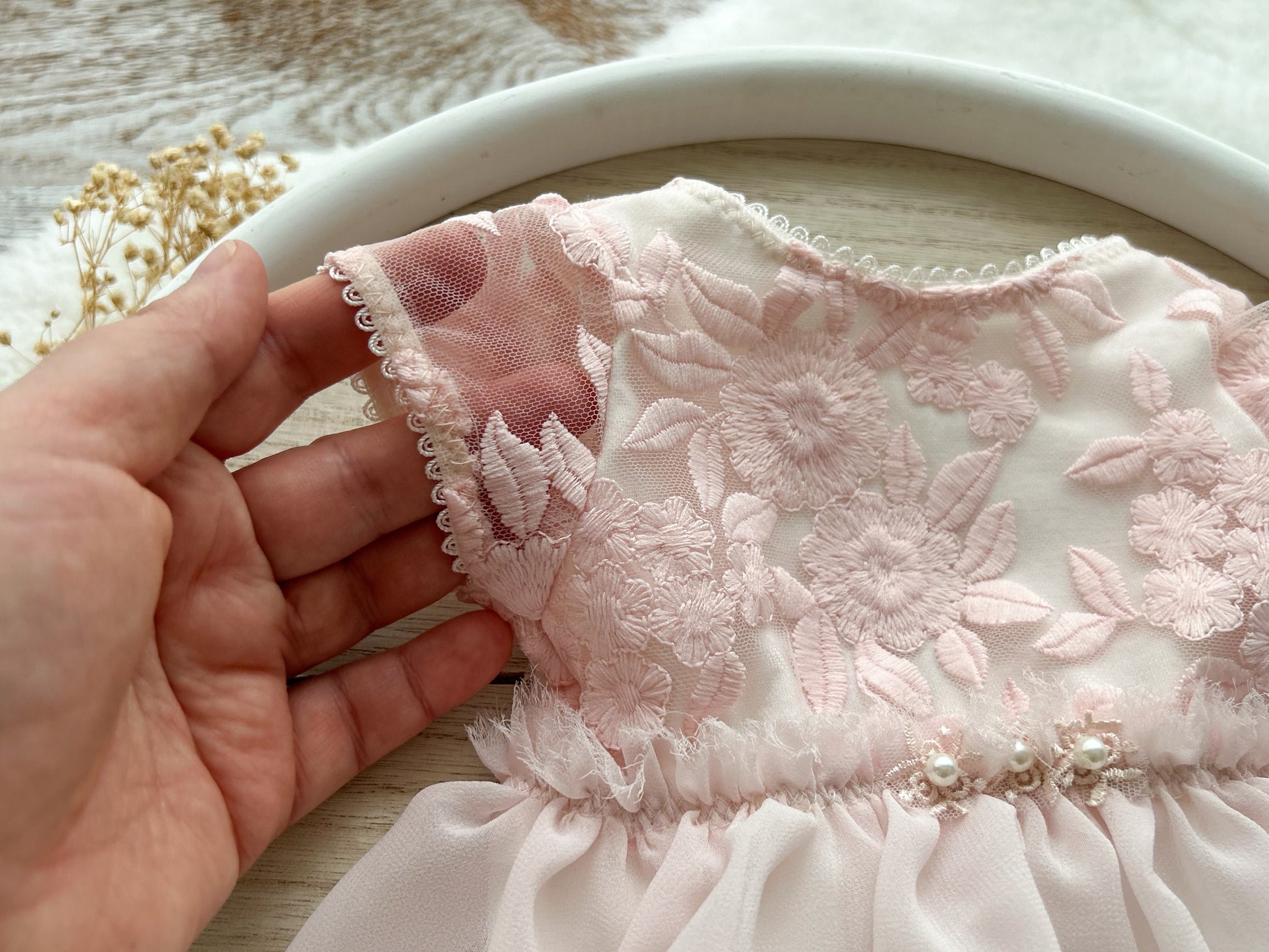 Close up on short lace sleeves of a newborn photo outfit