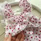 The back of newborn girl romper light pink color bright pink polka dots
