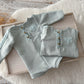 Duck egg blue newborn romper with matching sleepy hat on soft cream background

