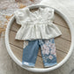 White blouse with floral pants on a white plate on a wooden surface