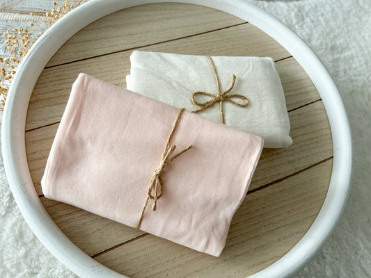 Stretchy fabric wraps for newborn photography in two color options: ivory or blush
