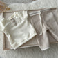 Detail of soft corduroy texture and cream top with rustic style baby buttons