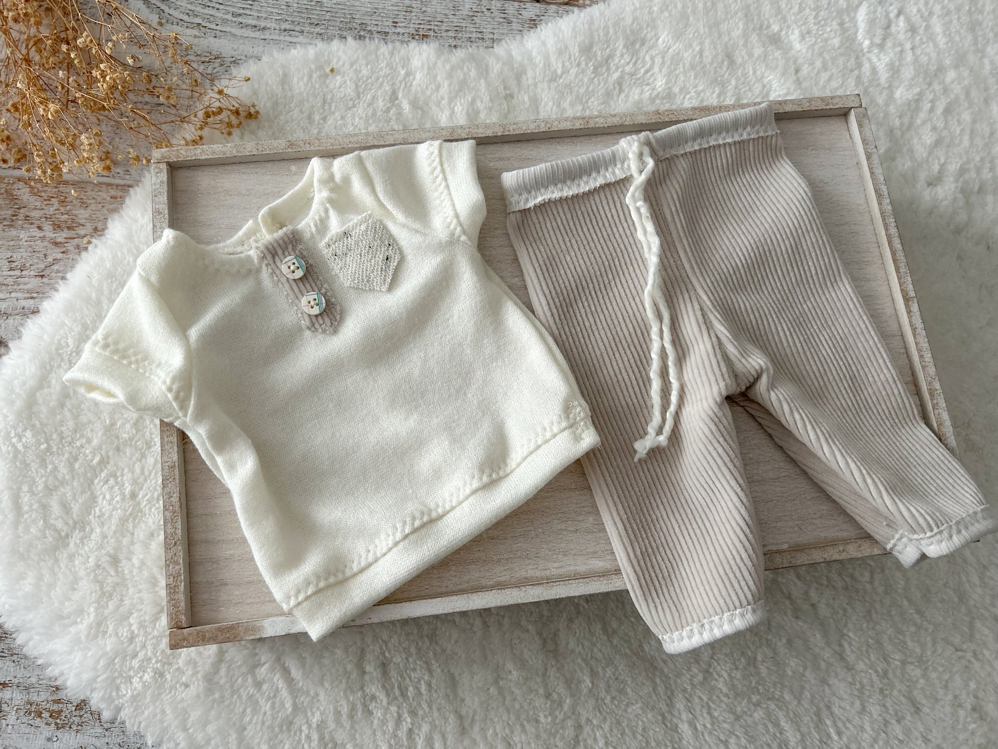 Detail of soft corduroy texture and cream top with rustic style baby buttons
