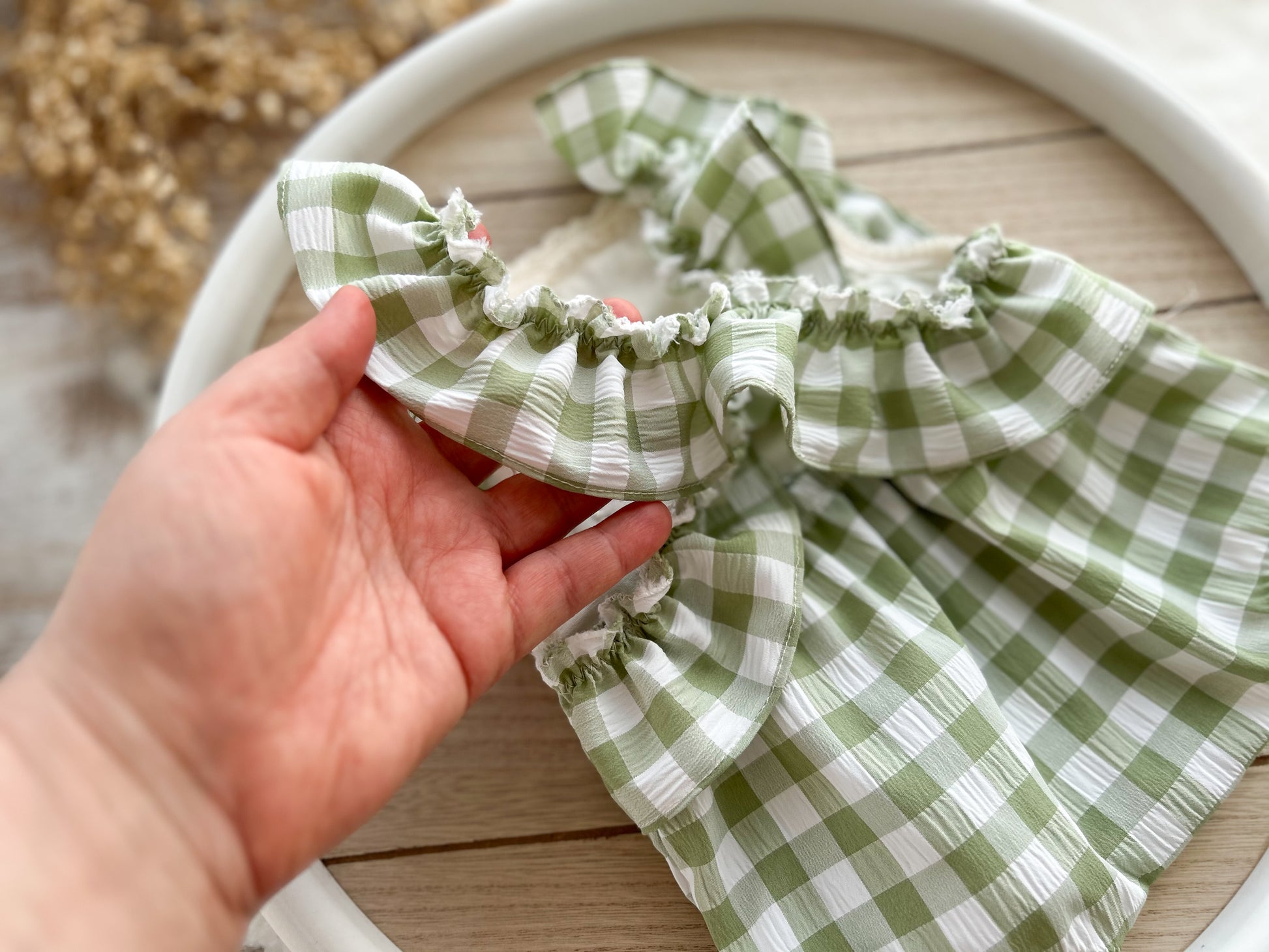 The back of the green and ivory romper with ruffles on the back, perfect as newborn photography prop