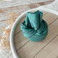 forest green baby photo wrap on a wooden tray