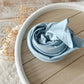 Sky blue cotton wrap for newborn photography, rolled and ready for use.