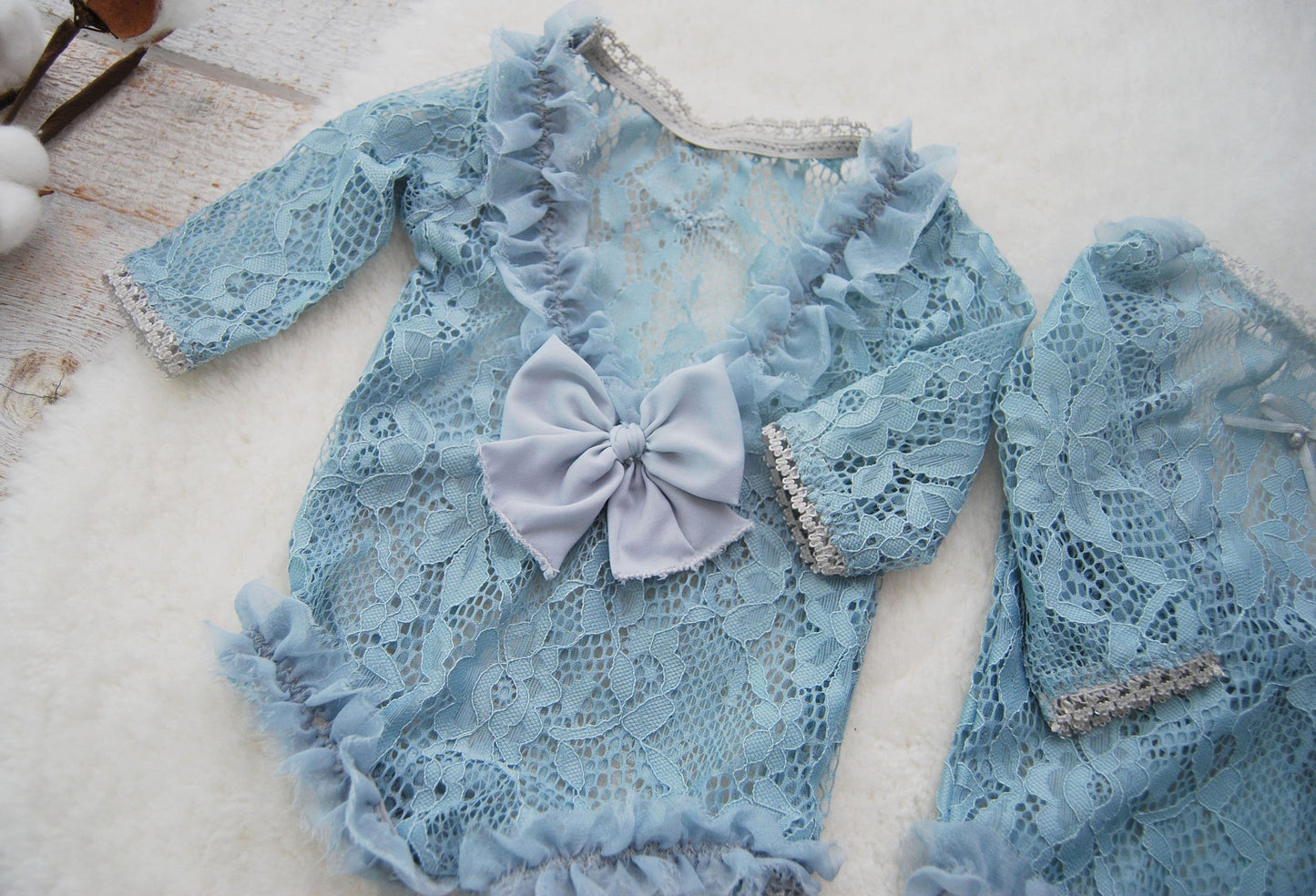 Details on the back of the newborn girl romper that is decorated with ruffles and bow.