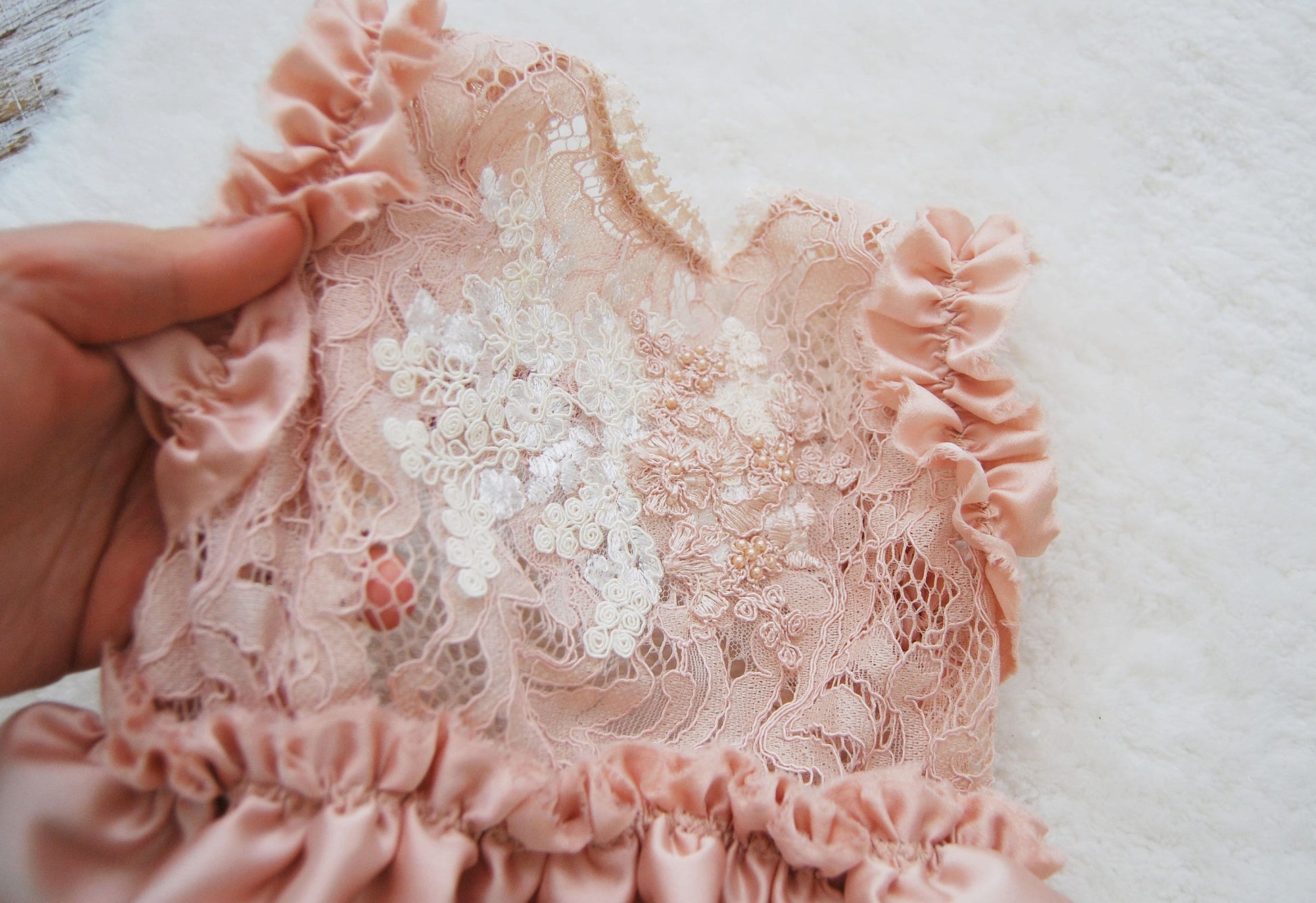 Sitter girl romper for photo shoots. Close-up on the floral texture of the lace.