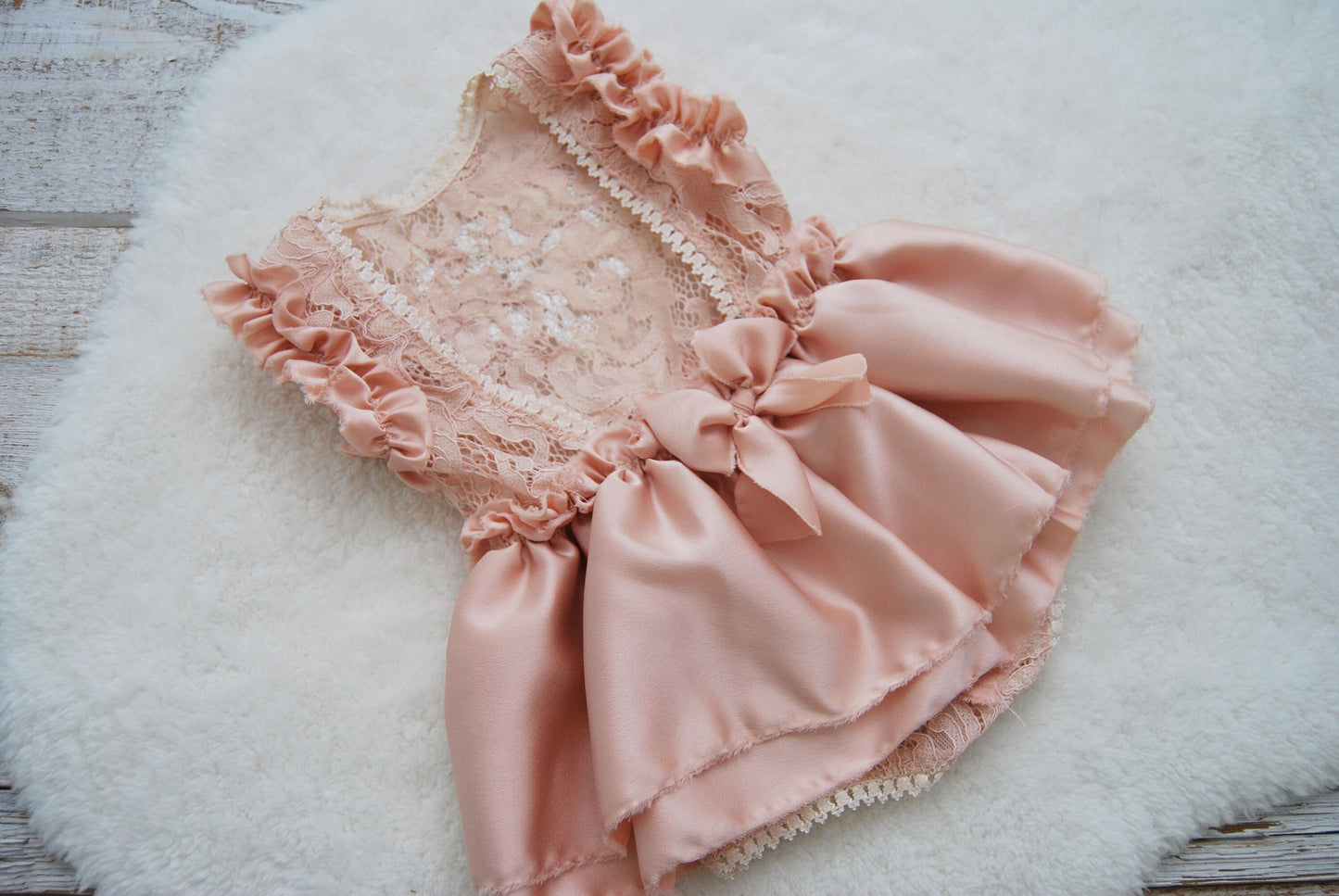 Sitter romper for photography shoots, dusty pink color, lace and satin. Features no sleeves or legs, but ruffled arm openings and a rich satin skirt made of two layers of satin.